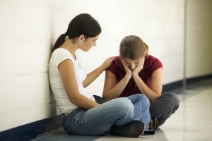 Teenage Girl Sitting in Hallway Consoling her Friend