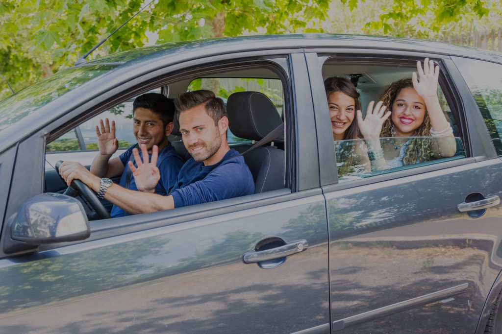 Group of people in the car waving hands