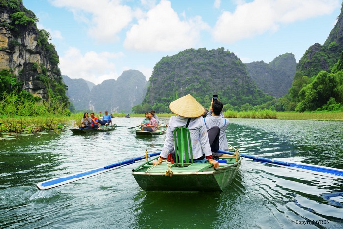 Tourists in boats. Rowers using feet to propel oars, Vietnam