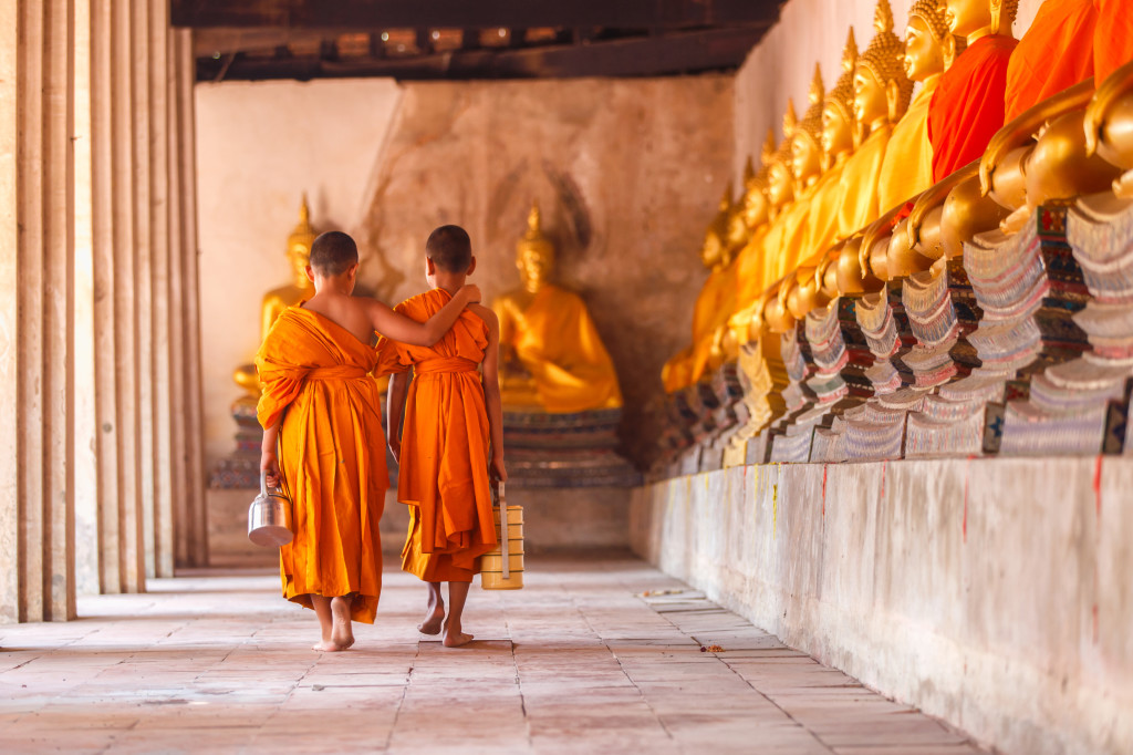 Two novices walking return and talking in old temple at sunset time, Ayutthaya Province, Thailand