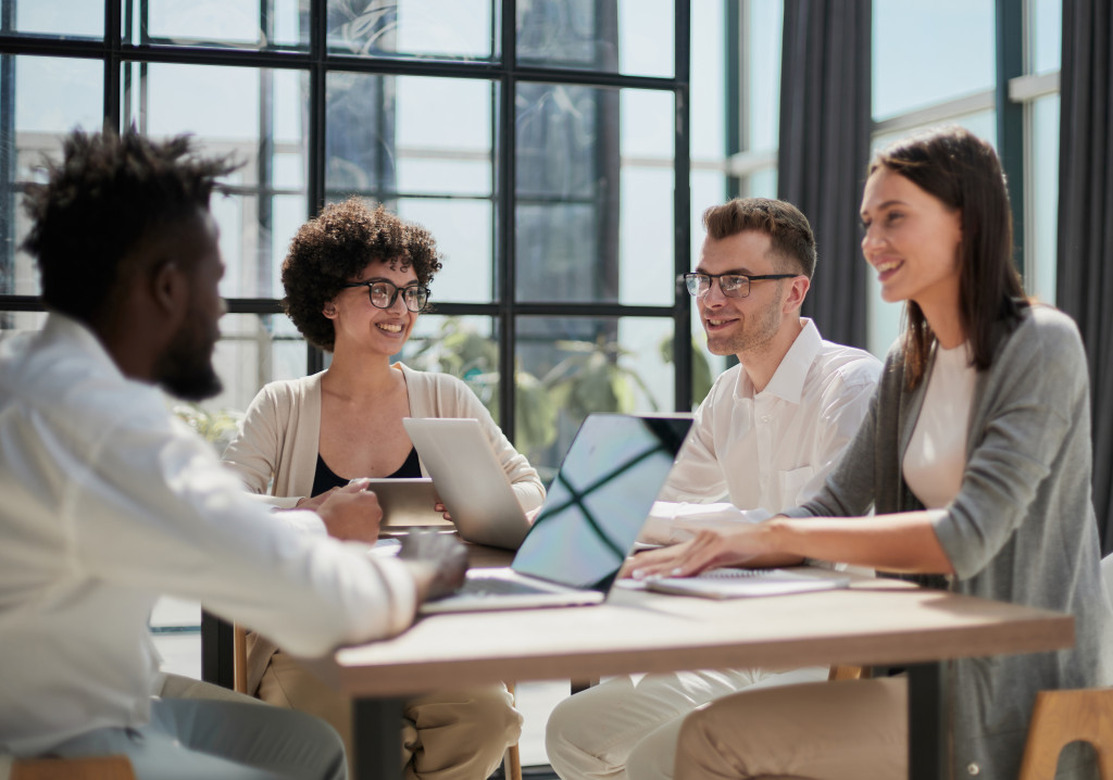 Employees working at computer together, discussing content